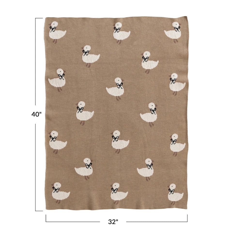 Tan cotton knit baby blanket featuring a white duckling pattern with dimensions 32 by 40 inches.