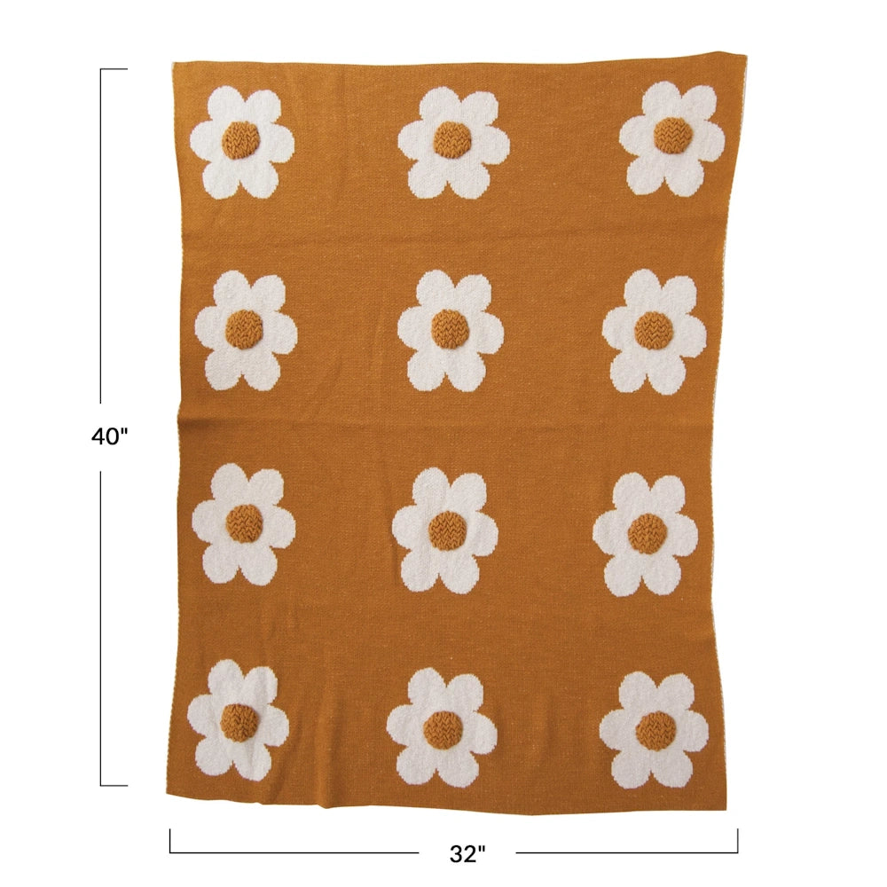 Mustard yellow knit throw blanket with white daisy pattern, measuring 32x40 inches.