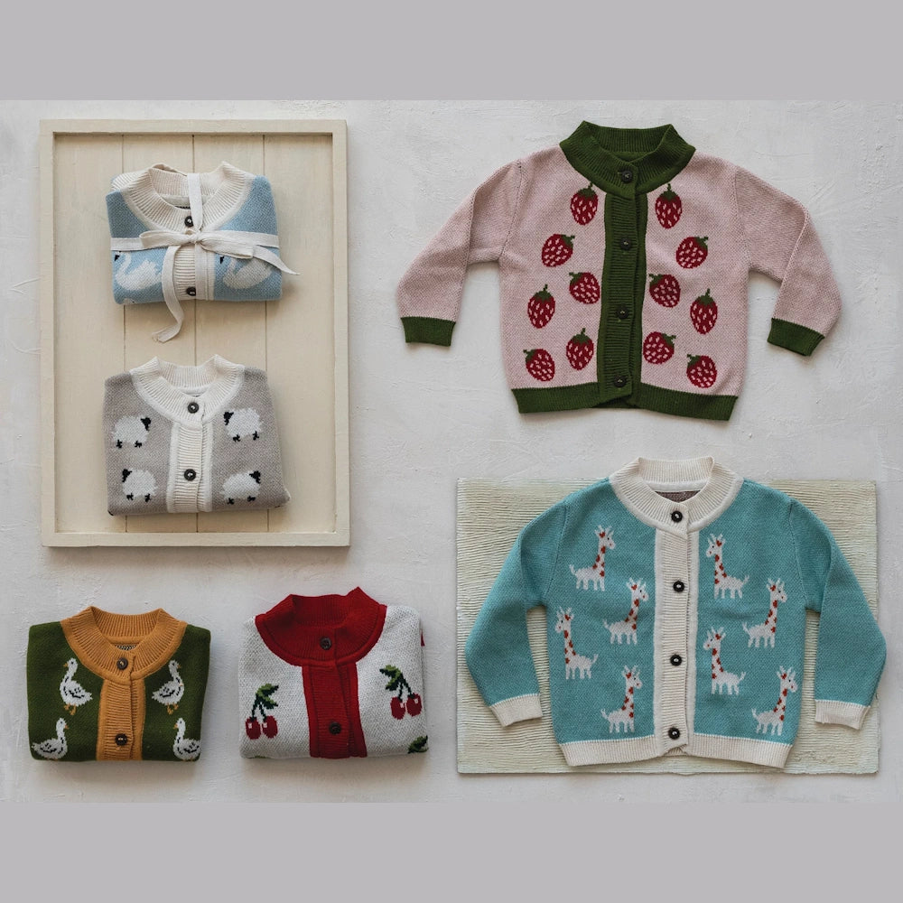 Assorted cotton knit baby cardigan sweaters with animal and fruit patterns, wood buttons, and ribbed trim on a white background.