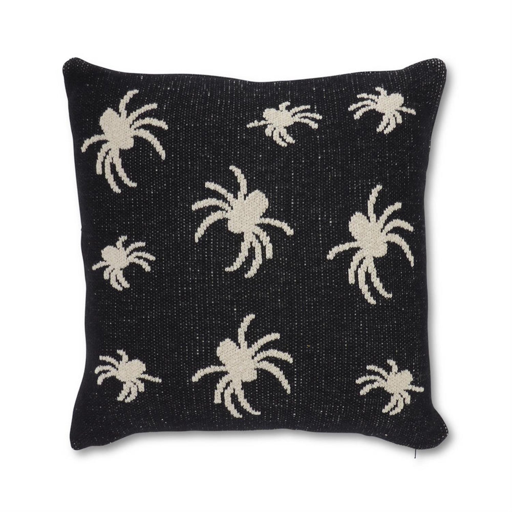 Black square knit throw pillow with a pattern of off-white spider silhouettes.