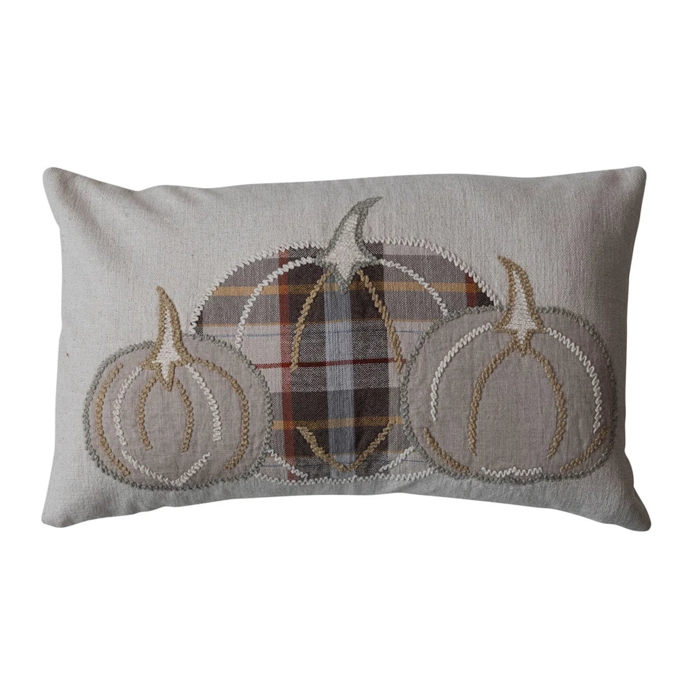 Beige lumbar pillow featuring three appliqued pumpkins, including a center plaid design and embroidered details.