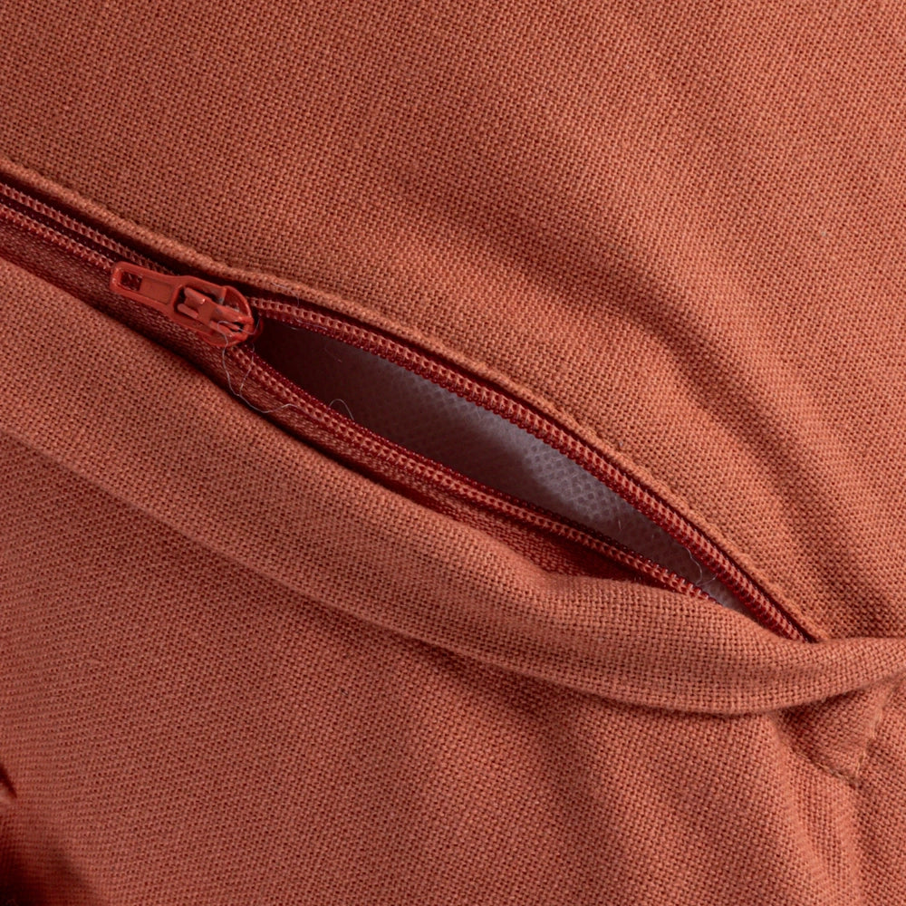 Terracotta decorative cushion cover with a concealed zipper and high-quality woven fabric detail.