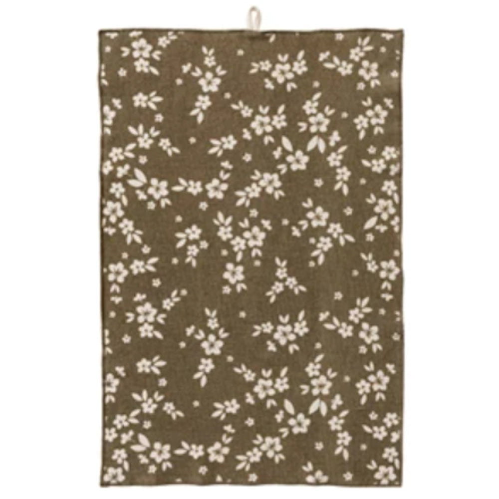 Olive green terry cloth tea towel with a white floral print and a top hanging loop for kitchen use.