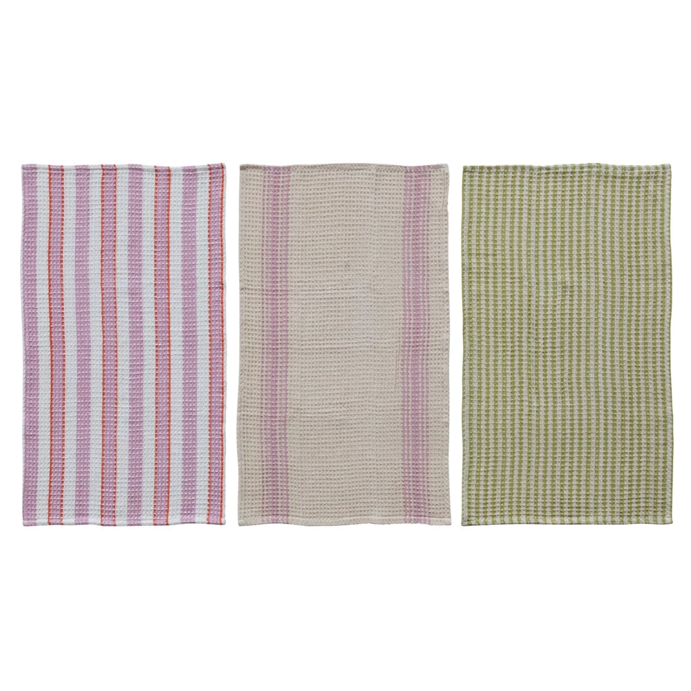 Three cotton waffle weave tea towels in pink, beige, and green striped patterns displayed on a white background.