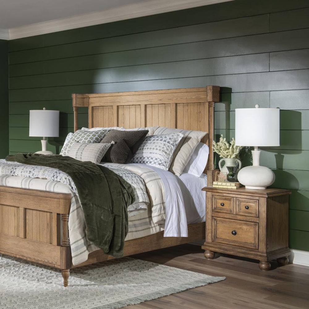 Rustic wooden bed with matching nightstand, white lamps, and green paneled accent wall.