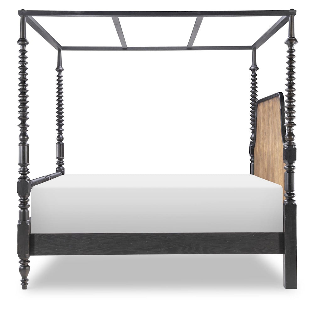 Side view of a black bobbin post canopy bed with tall turned posts and a wood panel headboard.