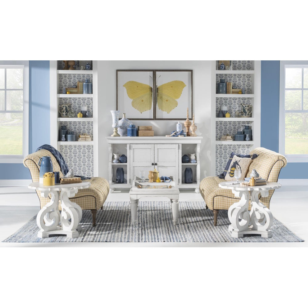 Living room with matching white scrollwork end tables, upholstered chairs, and blue and white decor accents.