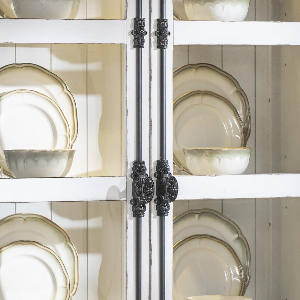 Rustic white hutch with black hardware and display of ceramic dinnerware and bowls.