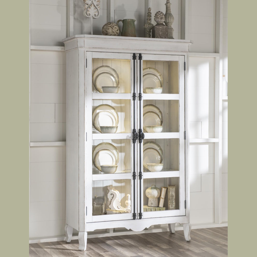 White distressed wood china cabinet with glass doors, lighted interior, and elegant dinnerware.
