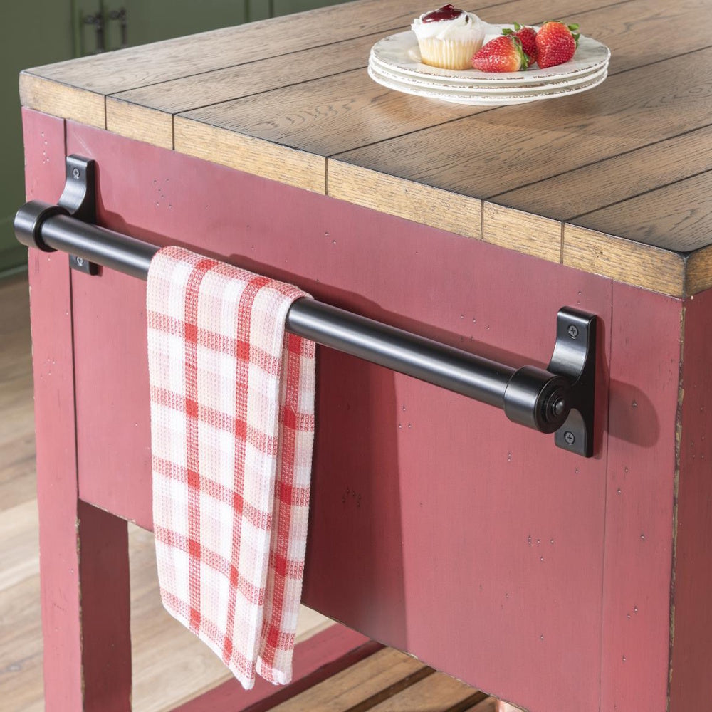Black industrial towel bar on a red kitchen island with a butcher block top.