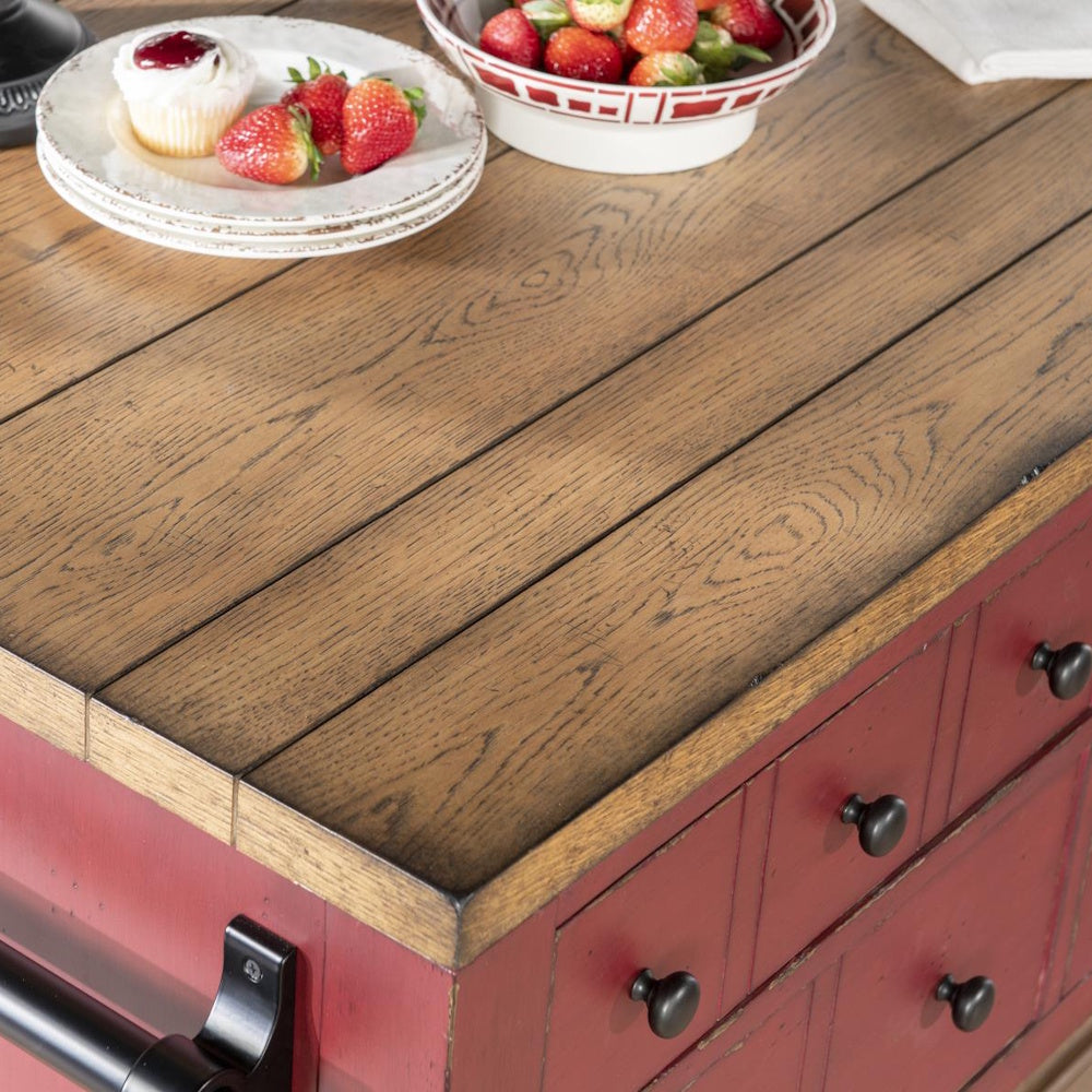 Rustic red kitchen island with natural wood countertop, fresh strawberries, and cupcake.