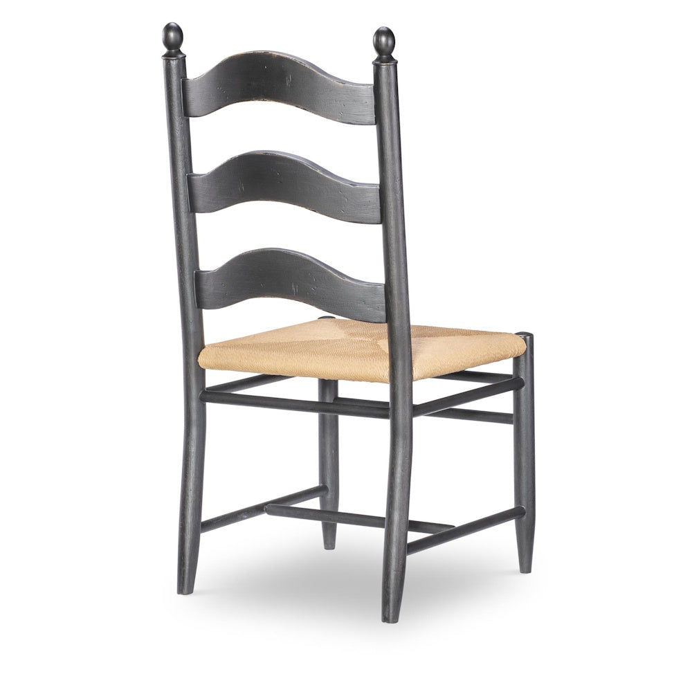 Back view of gray ladder-back wooden side chair with woven rush seat and turned finials on top posts.