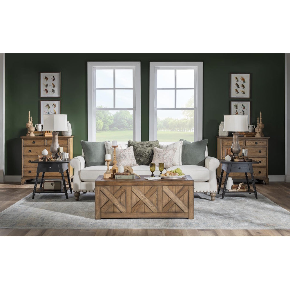 Living room with matching black end tables, white sofa, wood furniture, and dark green accent wall.