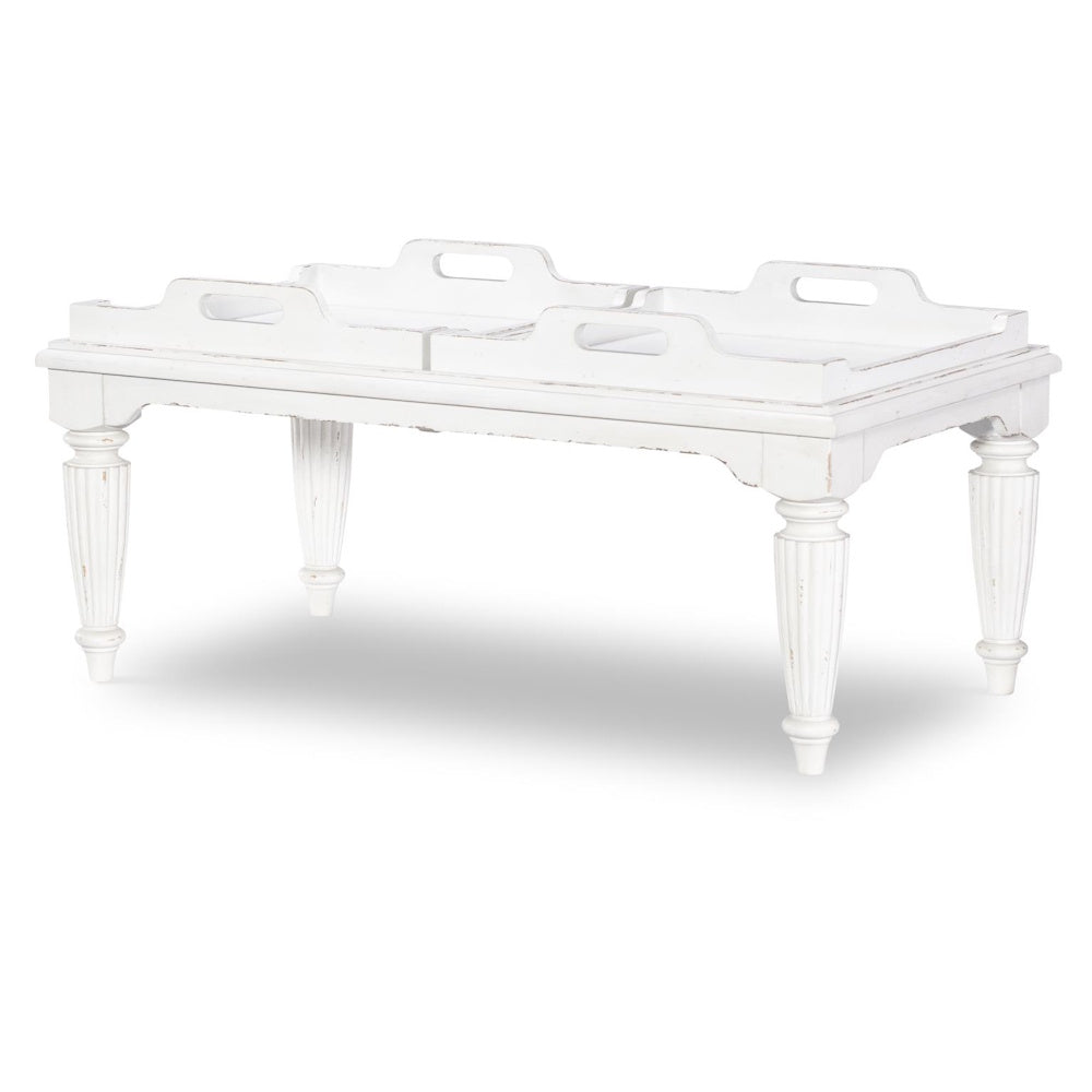 White, distressed country-style cocktail table with four removable tray tops and fluted legs.