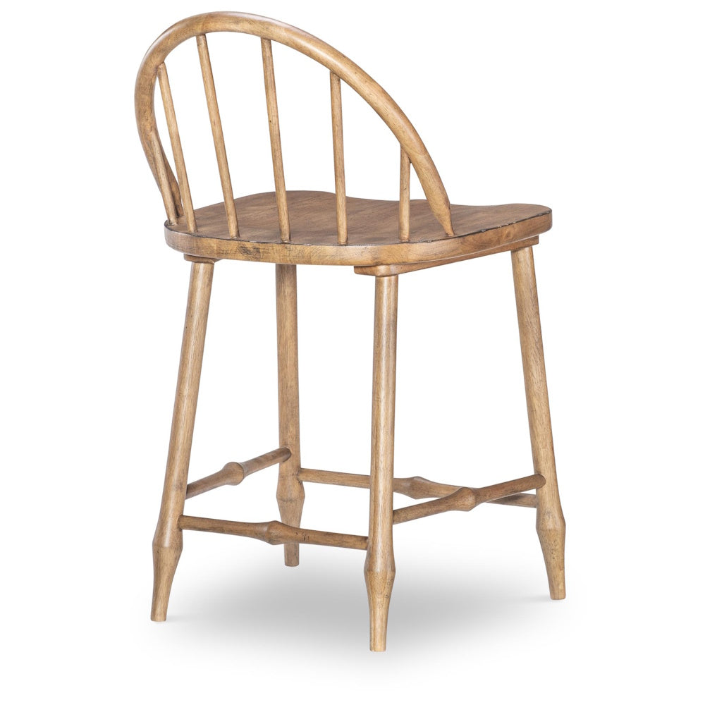 A rear view of a rustic wooden counter stool with a curved spindle back and turned legs.