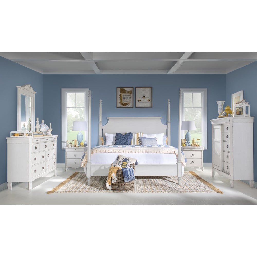 White four-poster bed set with matching dressers in a blue coastal bedroom.