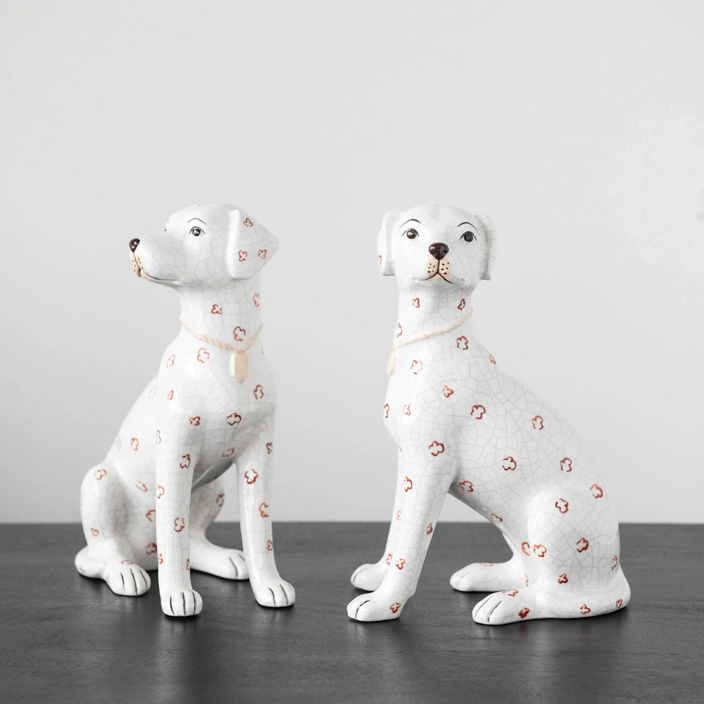 Pair of decorative Staffordshire ceramic dog figurines on a black surface.