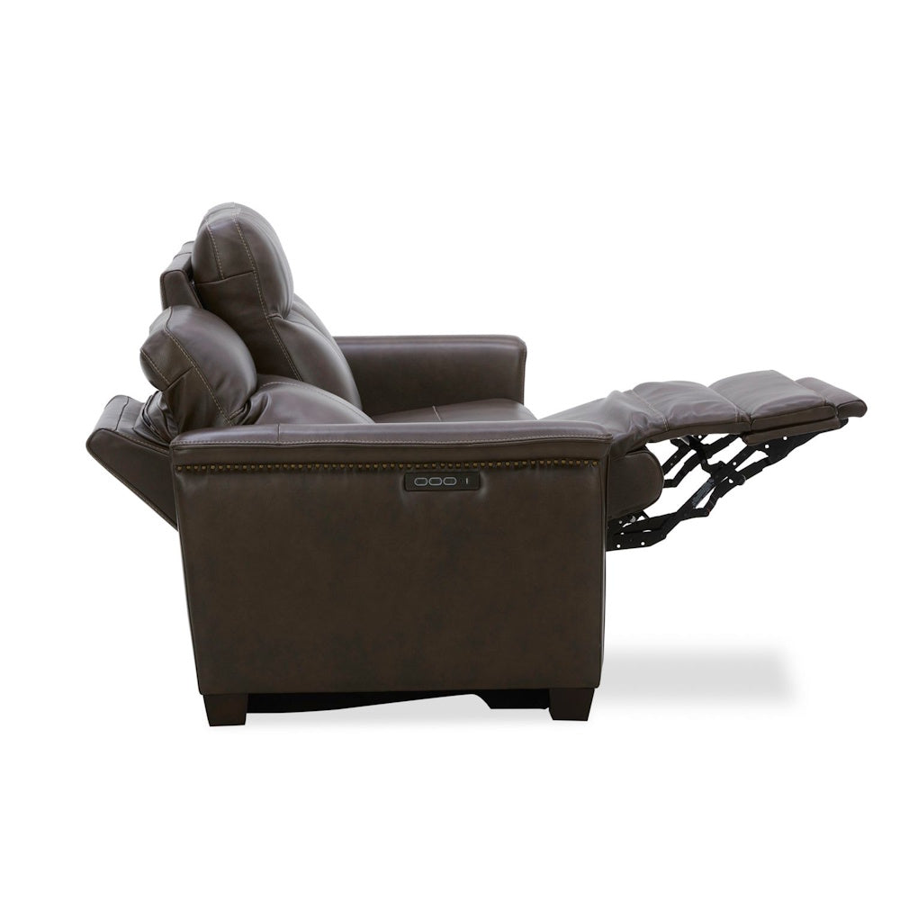 Brown leather power recliner sofa with adjustable headrest and footrest in side view.