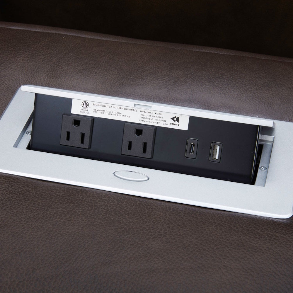 Pop-up power outlet strip for furniture with AC, USB-A, and USB-C ports on brown leather surface.