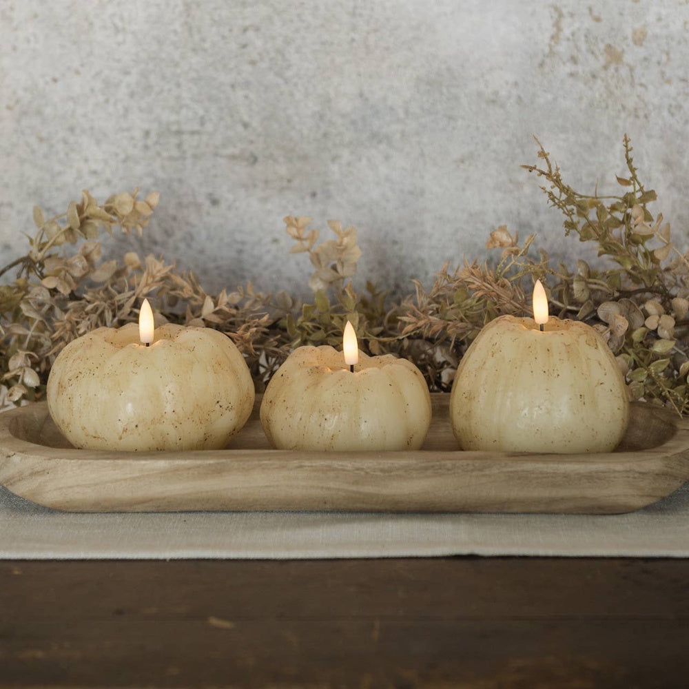 Three speckled cream pumpkin 3D flame candles in a rustic wooden dough bowl centerpiece decor.