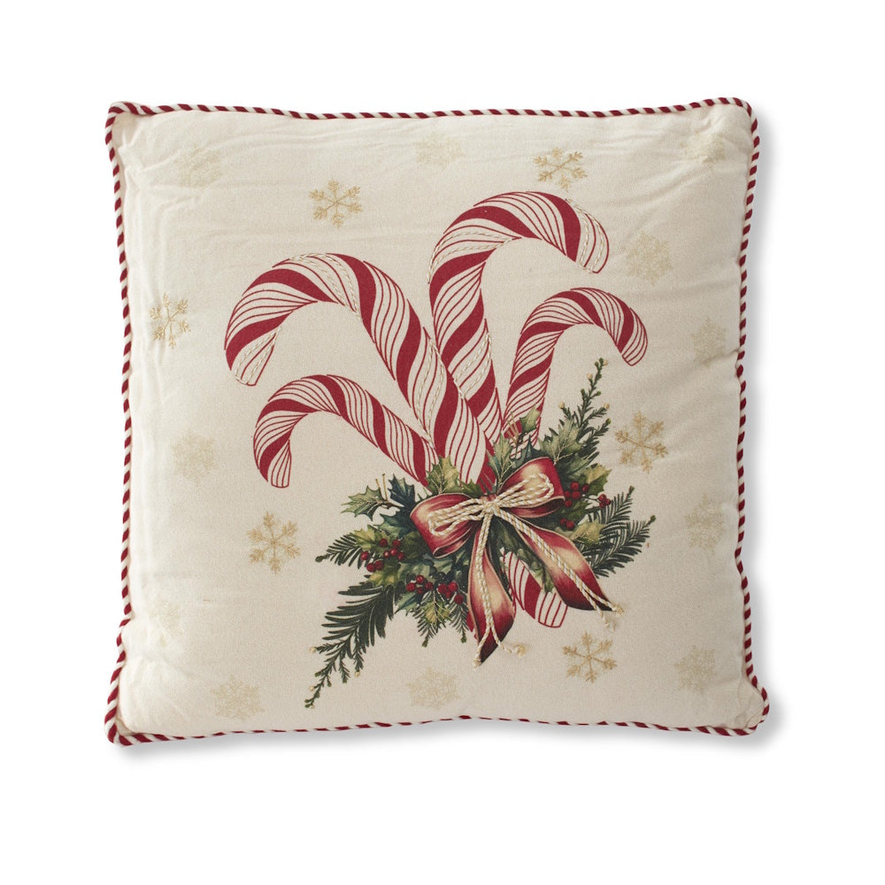 Cream square holiday pillow featuring red and white candy canes, pine sprigs, a red ribbon, and gold snowflakes.