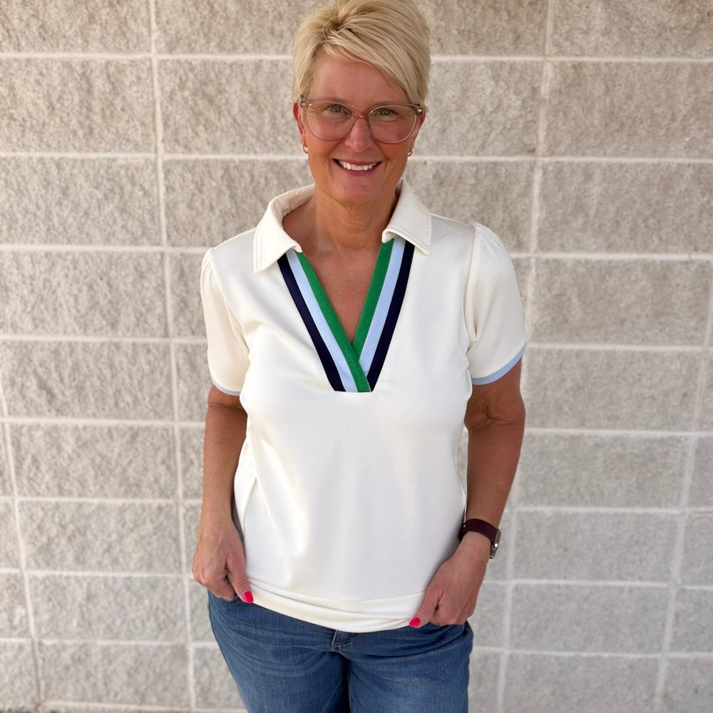 Cream luxe knit V-neck short sleeve top with green and blue striped collar trim.