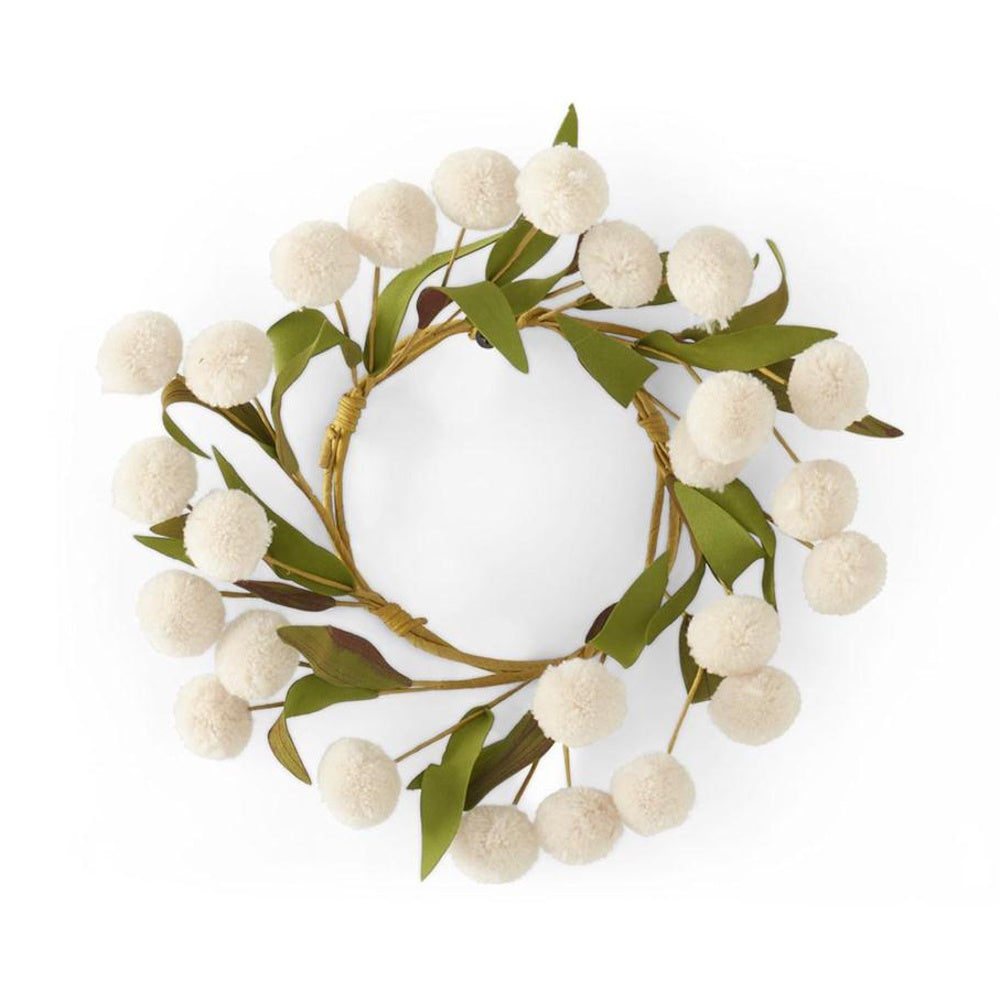 A circular wreath made of green leaves and white pom-pom flowers against a white background.