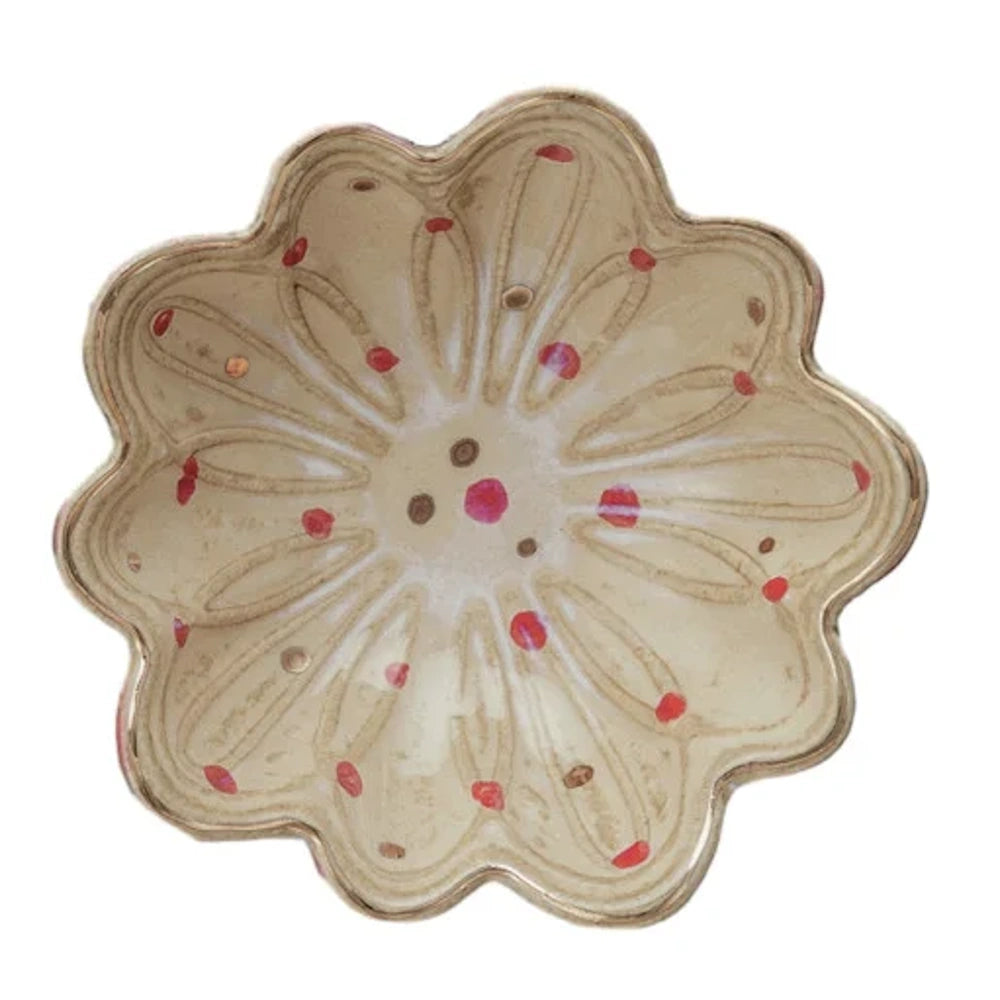 Cream round stoneware fluted dish featuring a scalloped flower shape, embossed patterns, and red and brown dots.
