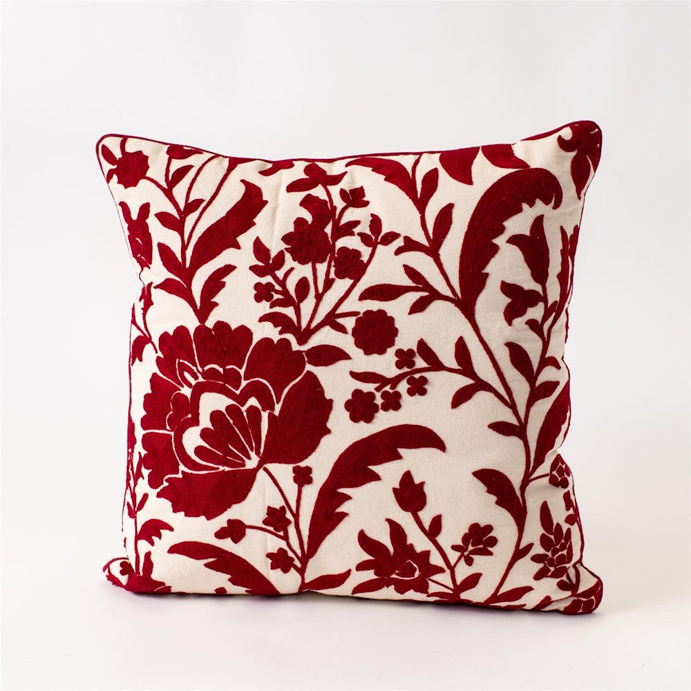 Square ivory throw pillow featuring red embroidered crewelwork floral patterns on a white background.