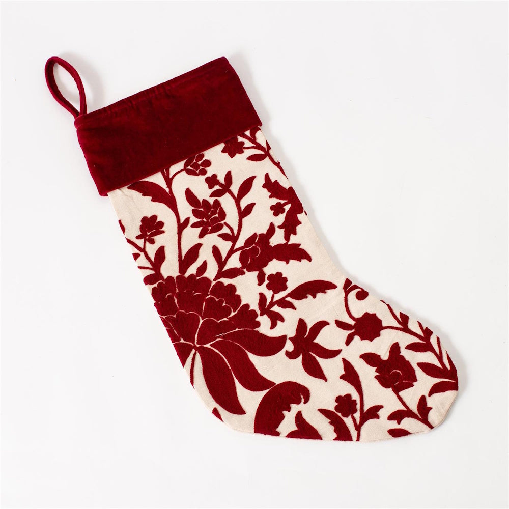 Cream Christmas stocking with dark red floral crewelwork and a solid red velvet cuff.