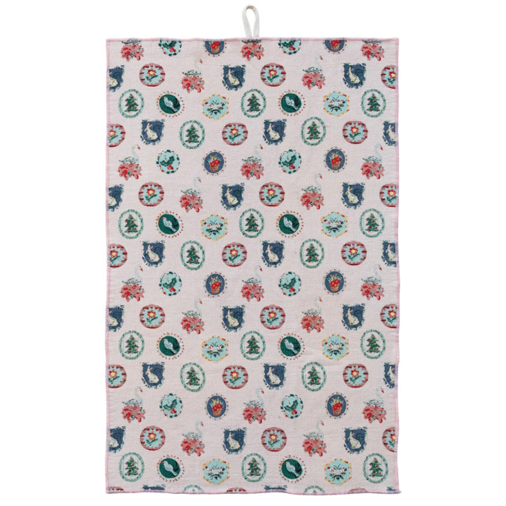 A cotton tea towel featuring a light background with various holiday and winter-themed medallion prints.