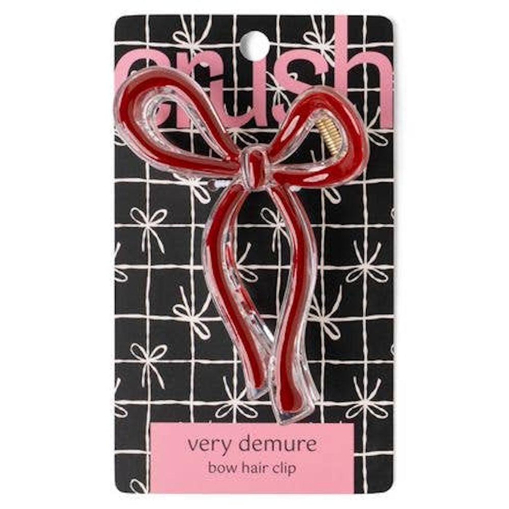Red Crush very demure bow hair clip with clear acrylic edges on a black and white patterned card.