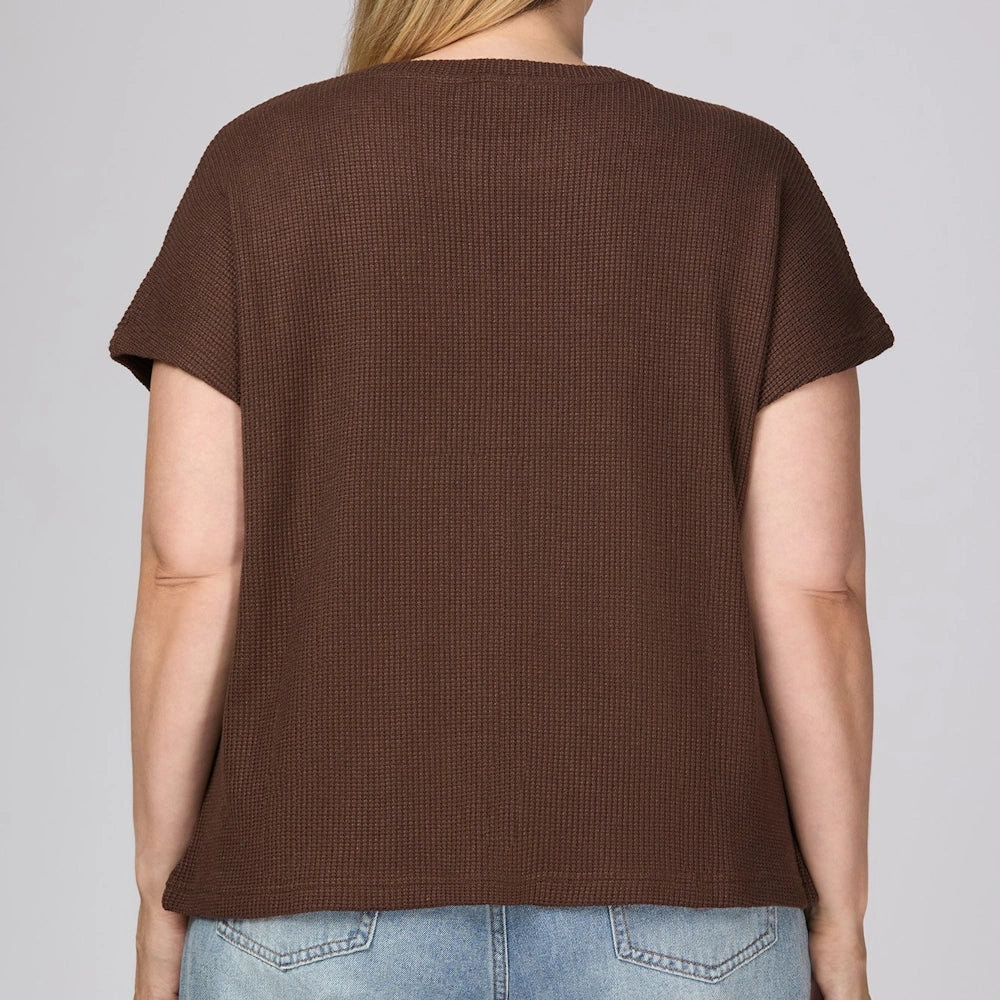 Back view of a brown drop sleeve knit top styled with light wash blue jeans.