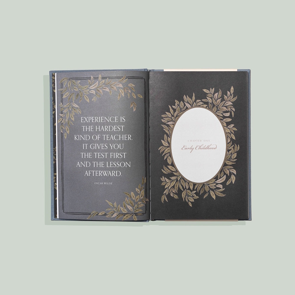 Open journal with an Oscar Wilde quote and "Chapter One: Early Childhood" on dark pages with gold leaf illustrations.