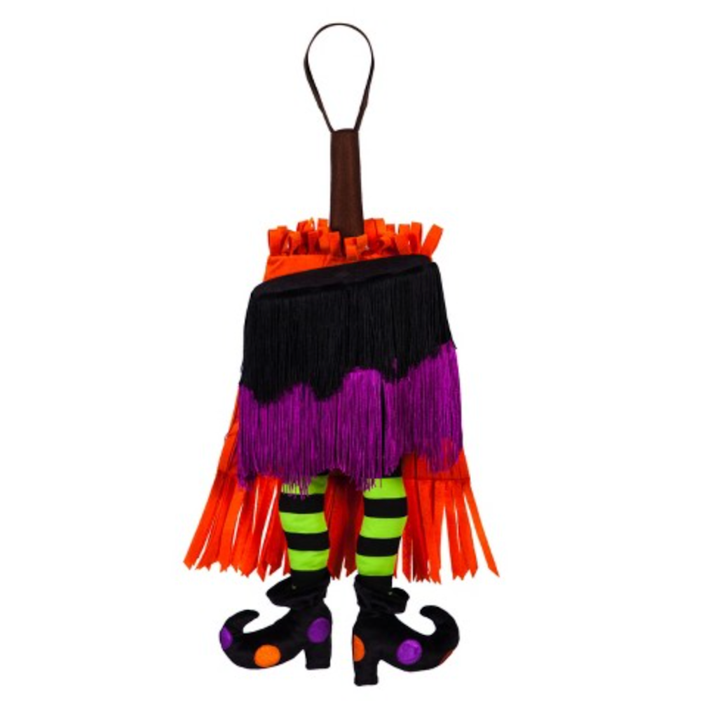 Hanging Halloween witch decor with fringe skirt, green-and-black striped legs, and polka dot curly boots.