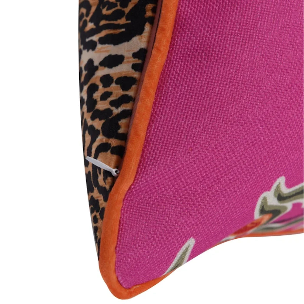 Pink throw pillow with orange trim, leopard print back, and hidden zipper. Clear view of textured fabric and stitching.