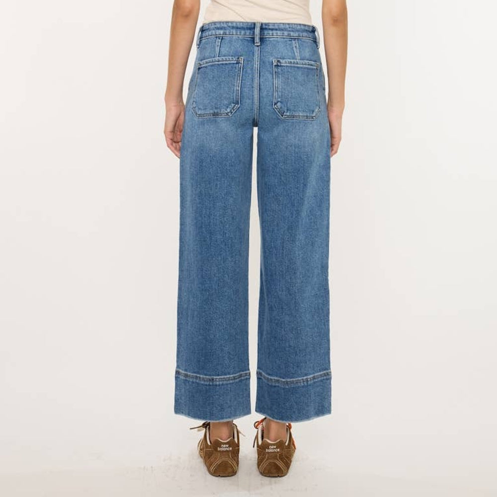 Back view of high-rise wide-leg blue jeans featuring back patch pockets and wide hem detailing.