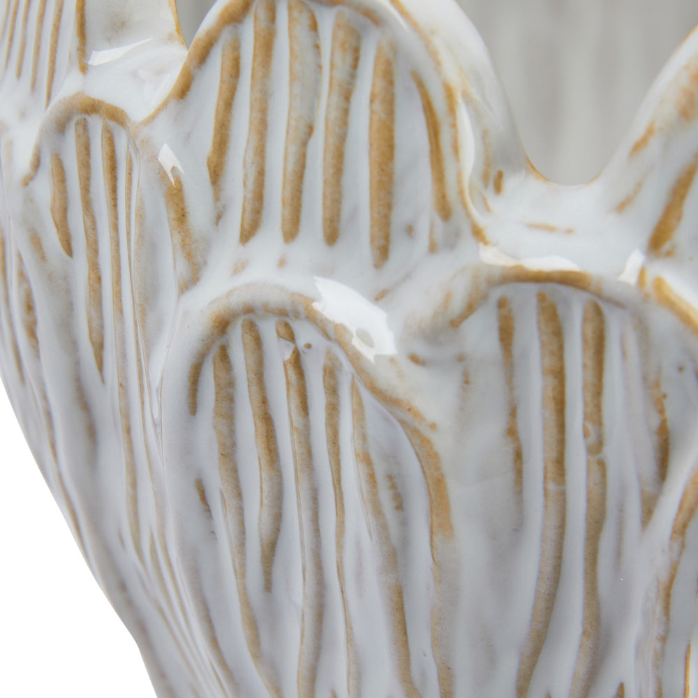 Close-up of a white glazed ceramic planter with textured tan debossed vertical ridges.
