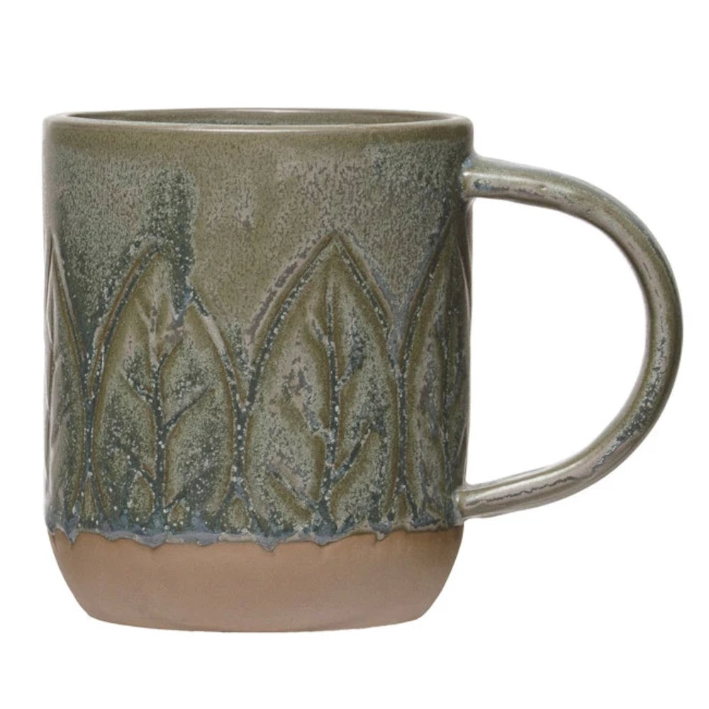 Green ceramic mug with embossed leaf pattern and rustic unglazed clay base on white background.