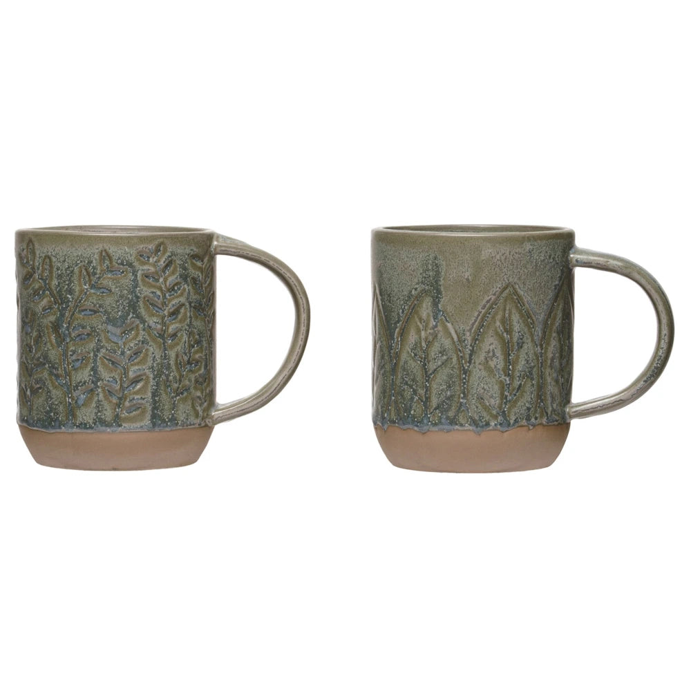 Pair of rustic green stoneware coffee mugs featuring textured botanical leaf designs on a white background.