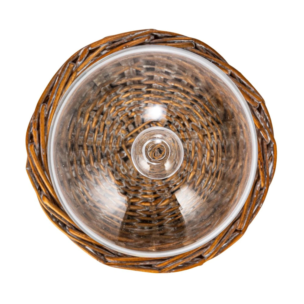 Top-down view of a clear glass cloche dome showing its round knob handle, set over a woven willow base.