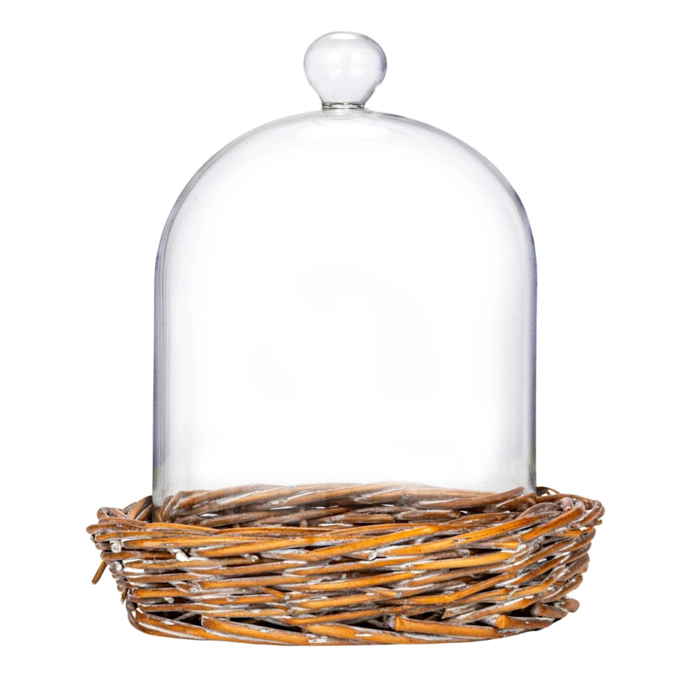 Clear glass dome cloche with a round glass knob top sitting on a woven rustic brown willow base.