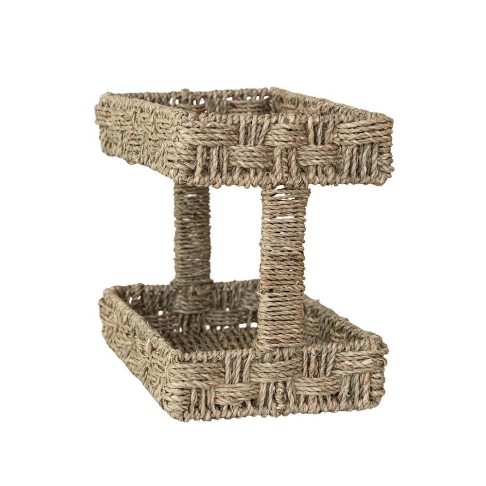 Rear three-quarter view of a empty two-tier hand-woven seagrass tray on a plain white background.