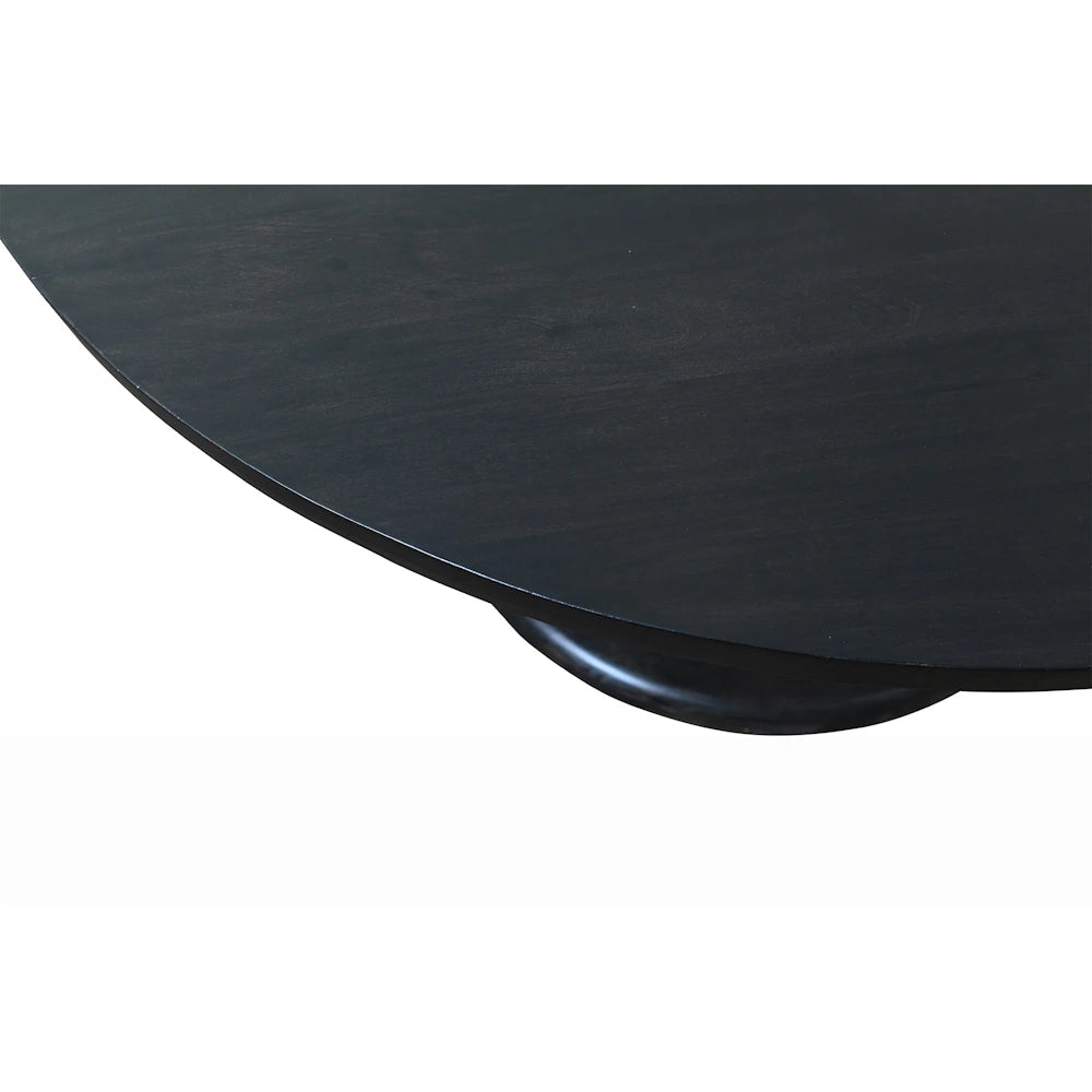Close up of black round dining table edge with visible wood grain and smooth beveled tabletop profile.