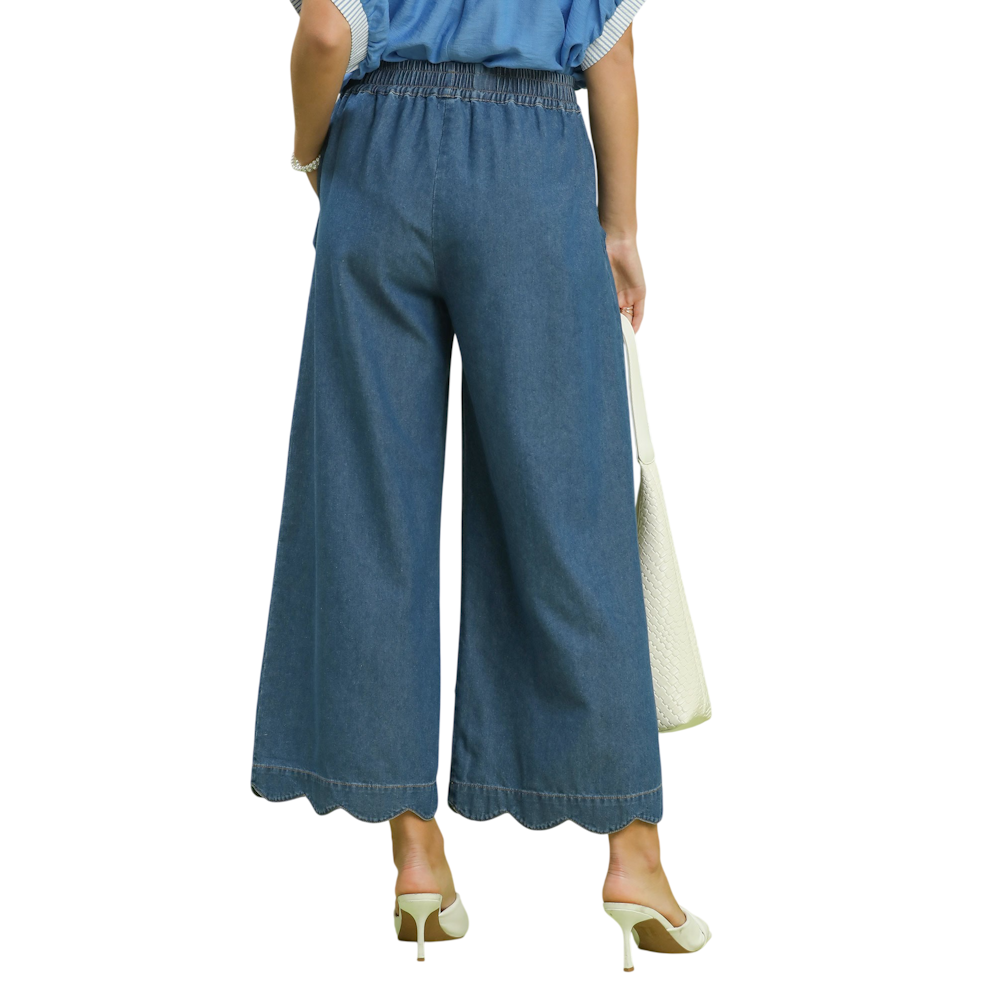 Back view of wide-leg denim chambray pants featuring an elastic waistband and scalloped hems.