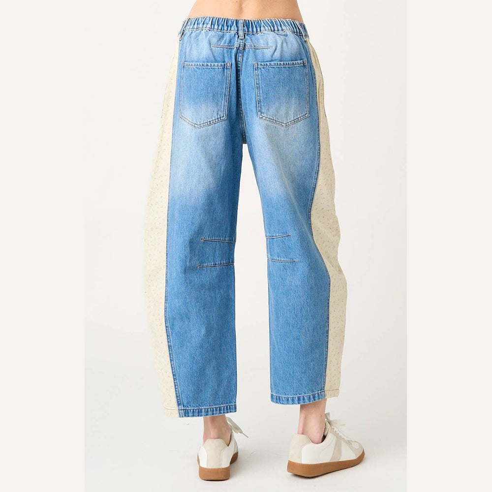 Back view of denim barrel jeans with cream floral print side panels and a comfortable elastic waistband.