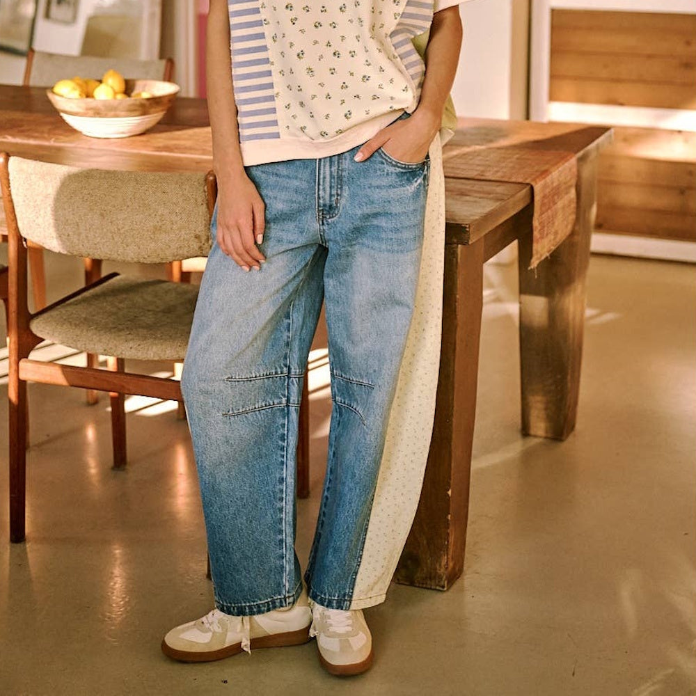 Women's barrel leg jeans in medium wash denim with cream floral print contrast side panels and elastic waist.