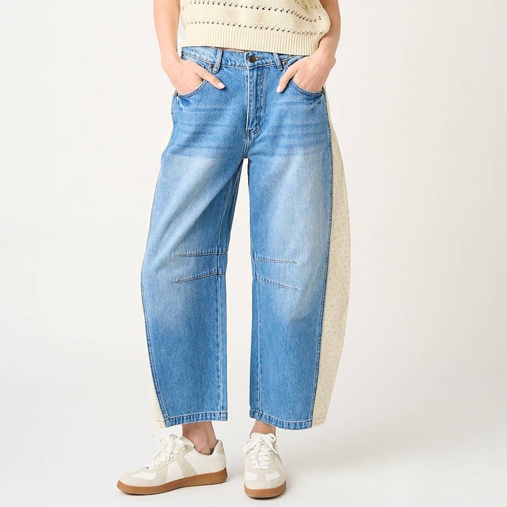 Medium wash barrel jeans with cream floral print side panels and contrast elastic waist for a boho-chic look.