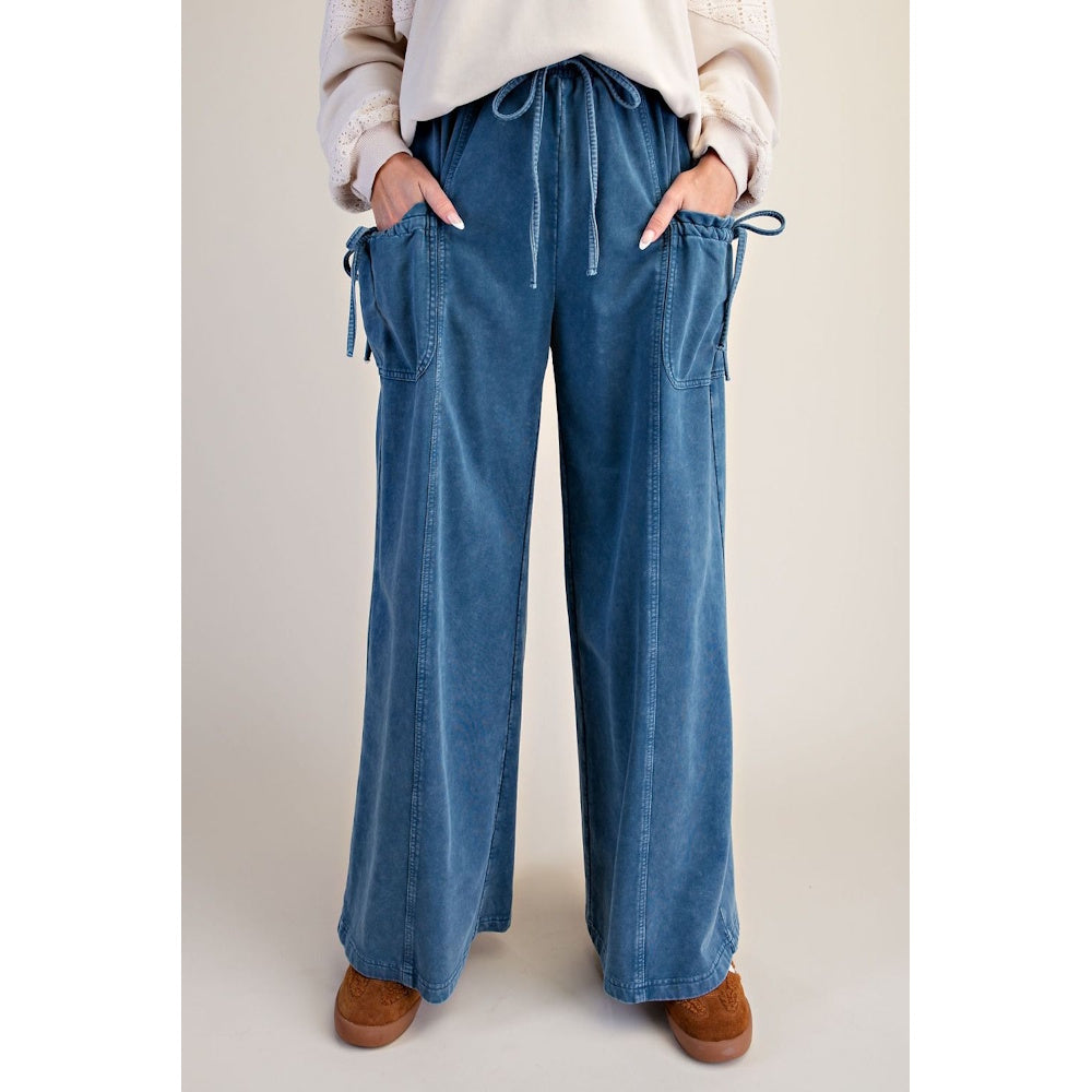 Front view of blue denim washed terry knit wide-leg pants with drawstring waist and tie-accent pockets.