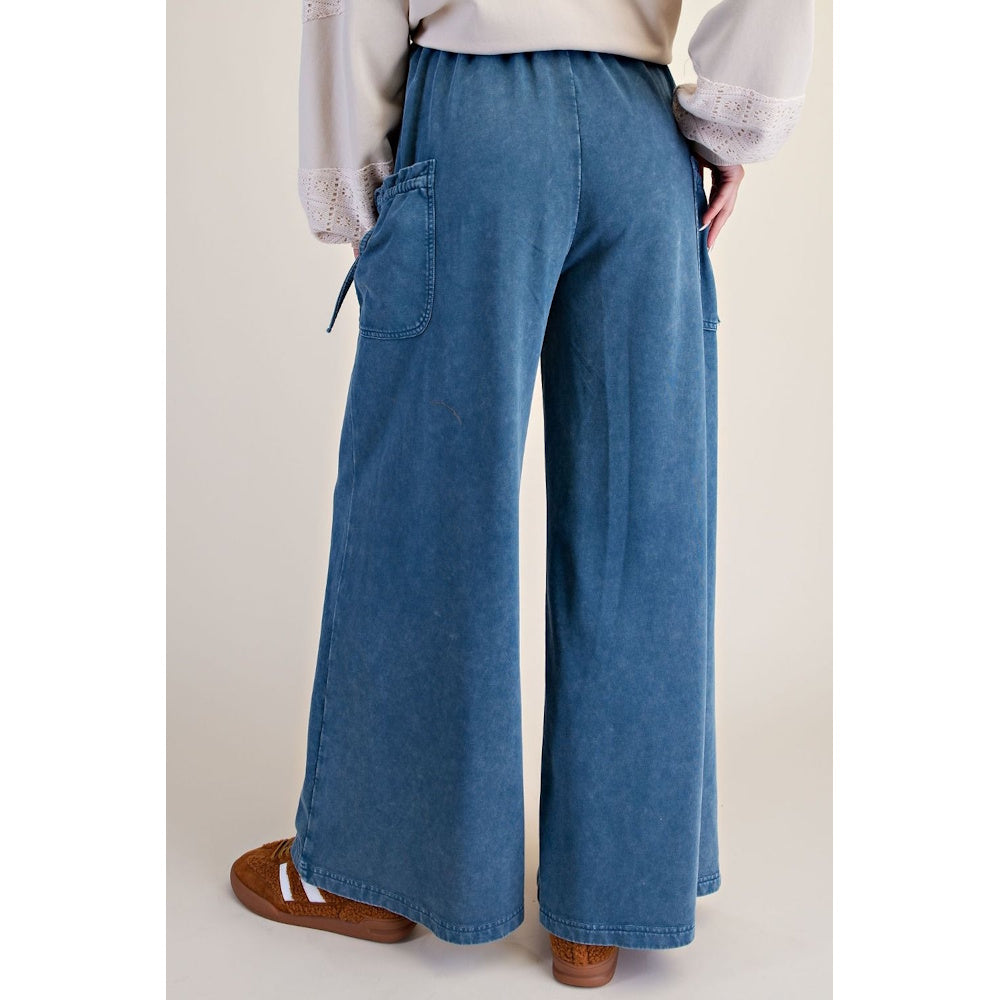 Back view of blue denim washed terry knit wide-leg pants with elastic waistband and side pockets.
